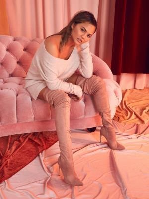 Chrissy Teigen models boots, and apparel from her Revolve collab